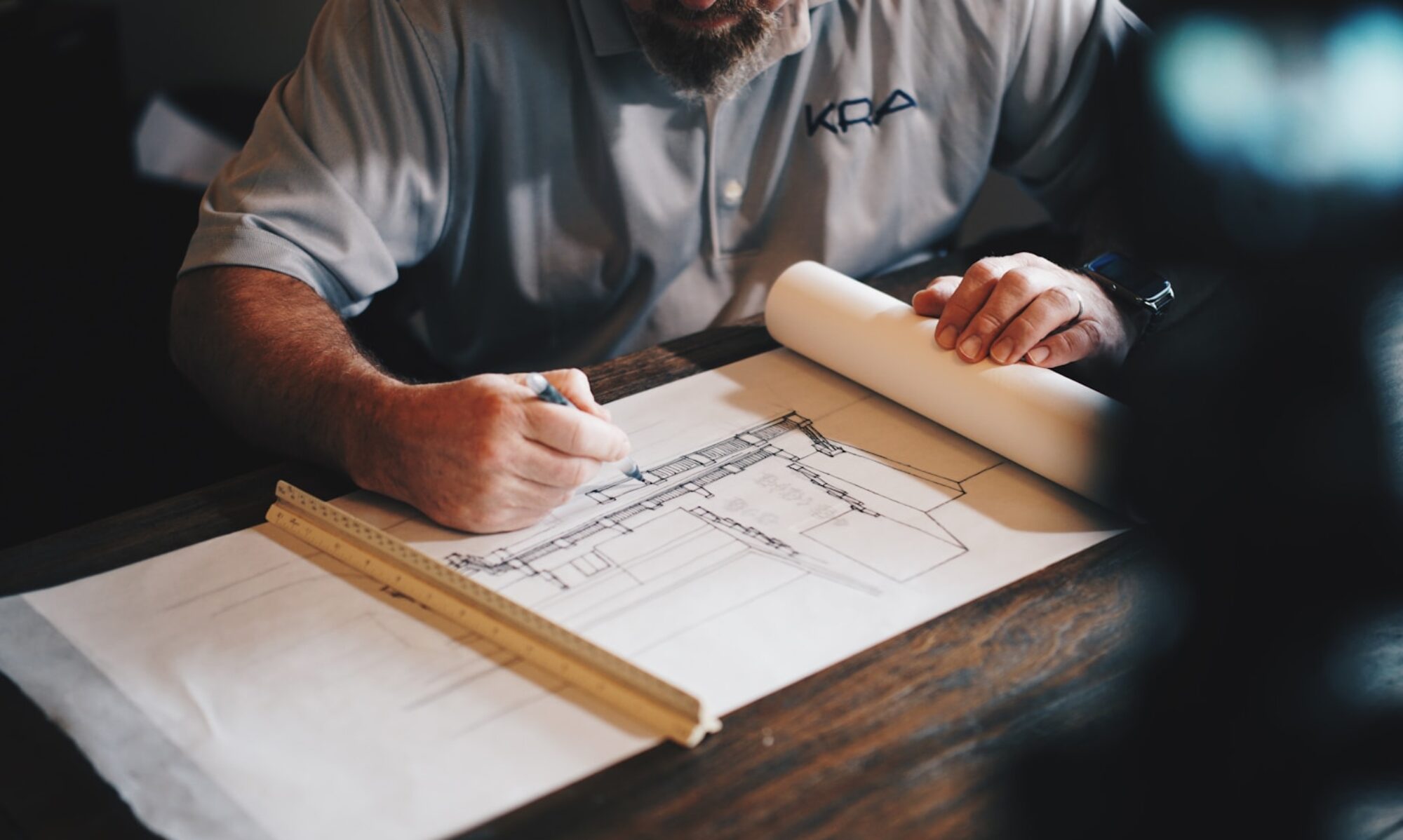 An architect working on a draft with a pencil and ruler